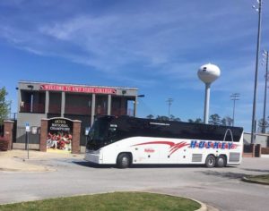 Huskey Bus sitting in front of a baseball field entrance