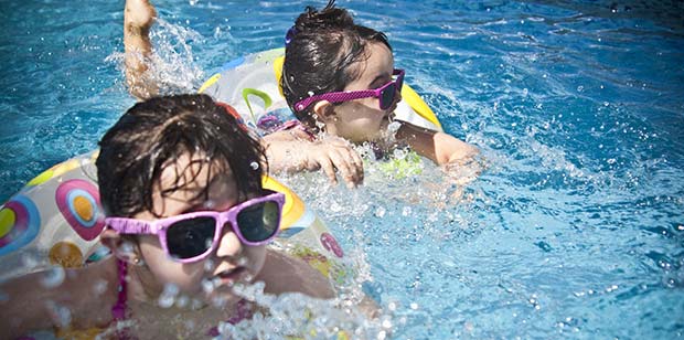 Children swimming in inner tubes at a pool in Osage, MO